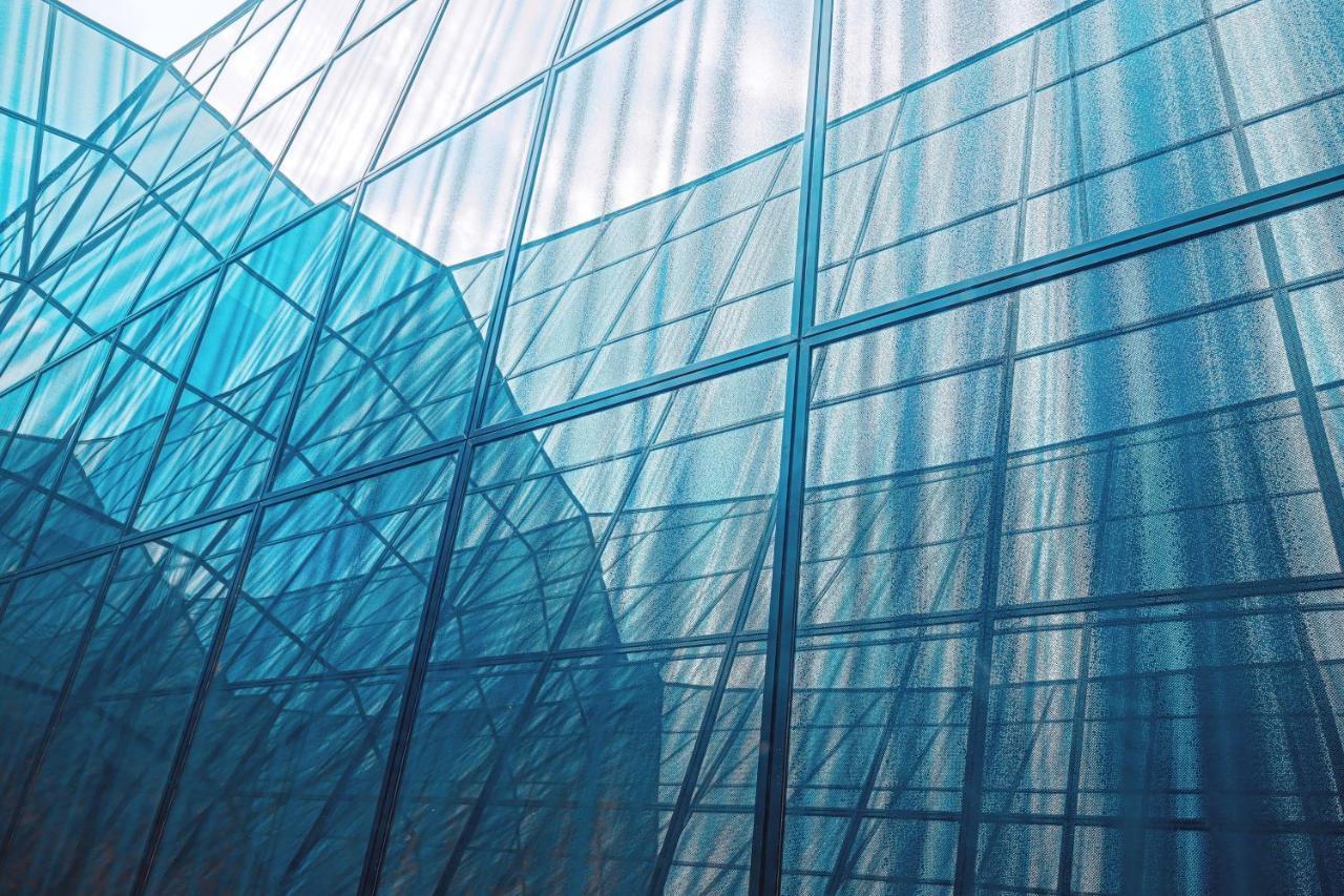 The Westin Hamburg Elbphilharmonie Hotel Ngoại thất bức ảnh The photo shows an architectural structure with a facade made of glass. The glass panels are arranged in a way that creates a reflective and translucent effect, with various shades of blue dominating the image. The interplay of light and shadow creat